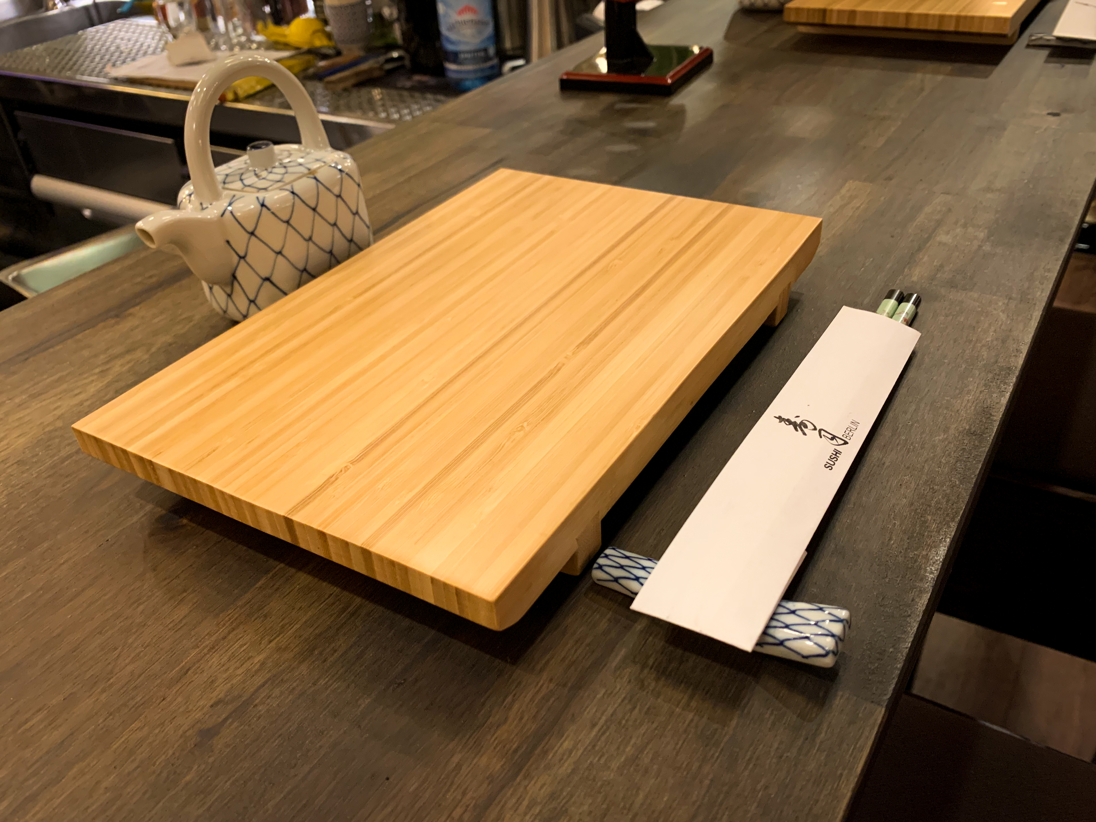 Wooden plate over the bar table with chopsticks