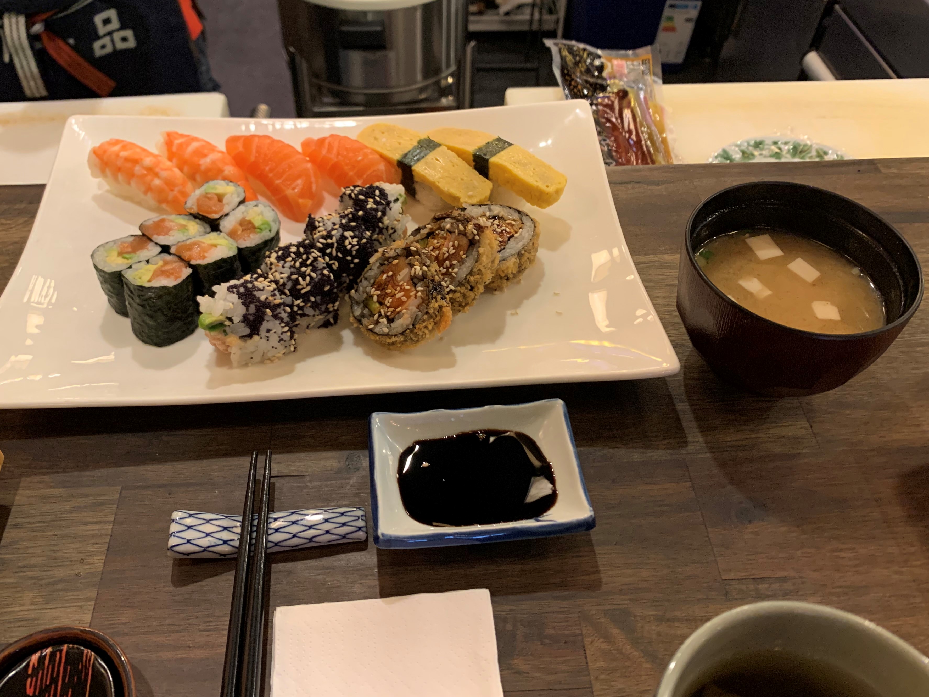 Table with a sushi plate, sushi, shoyu sauce and a soup